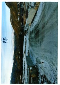 Fotografi av en snødekt vei og en bygning i et fjellområde.