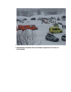 Fotografi av en snødekt utendørs arena med parkerte biler, ambulanse og redningspersonell under et arrangement (Motbakkeløpet 8. september 2013).