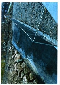 Fotografi av en byggeplass med en ny anlagt vei, en steinmur og en midlertidig hekk.