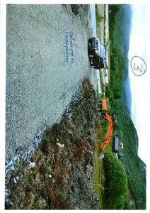 Fotografi av en byggeplass med grusvei, gravemaskin og bil.