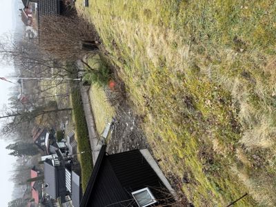 Fotografi av en tomt med grøfting og nabolag.