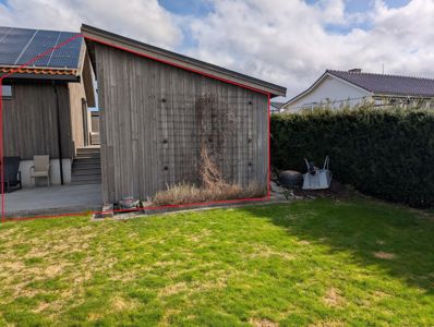 Fotografi av en bygning sett fra bakgården, med en rød linje som markerer fasaden.