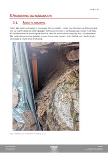 Fotografi av en utrasingsområde bak en håndsteinsmur med en dreneringsduk og et rør.