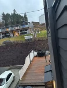Fotografi av en bygning under oppføring eller ferdigstilt, sett fra en høyde. Bildet viser en terrasse, en bil og nabolag.