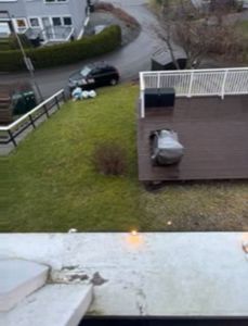 Fotografi av en terrasse, hage og nabolag sett fra et høyere nivå.