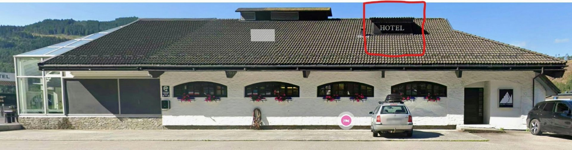 Fotografi av en hvit bygning med skiltet 'HOTEL' på taket, sett fra foran.