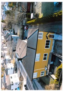 Luftfoto av en gulett hus med grå tak, sett fra en vinkel som viser både fasade og tak.