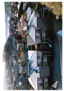 Luftfoto av et boligområde med flere hus og en rød markering som viser en vei eller grense.