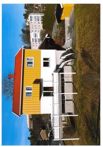 Fotografi av en gul og hvit villa med rødt tak, sett fra siden. Bildet viser bygningens fasade, trapper og omgivelsene.