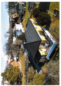 Luftfoto av en gulett hus med grå tak, sett fra en høyde.