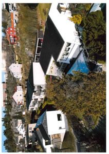 Luftfoto av en boligbebyggelse med flere hus og trær.