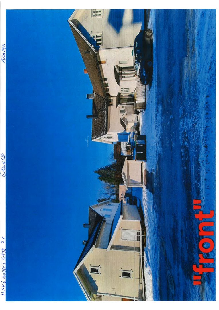 Fotografi av en eksisterende bygning (hus) sett fra foran, med snø på bakken og en bil parkert.