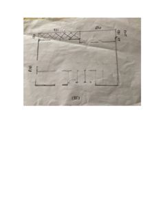 En håndtegnet etasjeplan som viser romfordeling, vegger og dører i en bygning.