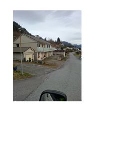 Fotografi av en eksisterende bolig og nabolag sett fra en vei.