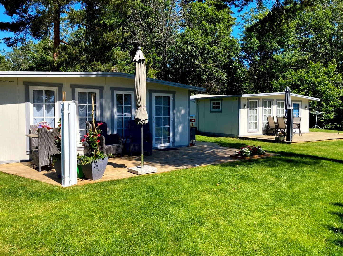 Fotografi av en ferdigstilt campinghytte eller mobilhus med en terrasse og omgivelser.