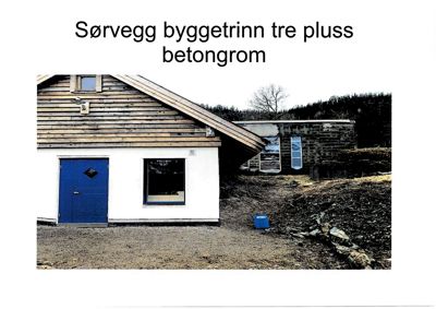 Fotografi av en bygning med tekst 'Sørvegg byggetrinn tre pluss betongrom'.