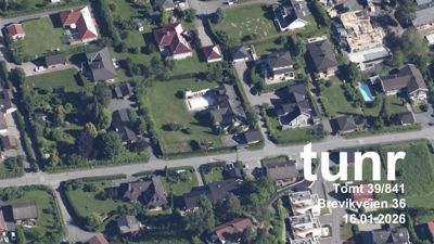 Luftfoto av et boligområde med hus, veier og grøntområder.