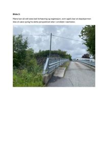 Fotografi av en vei med støyskjerm og vegetasjon i bakgrunnen.