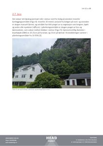 Fotografi av en hvit villa og en garasje sett fra nede, med skog og fjell i bakgrunnen.