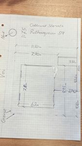 En håndskrevet situasjonsplan (tomteplan) med mål på eiendommen, bygningens plassering og orientering (Nord).