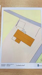 Kartutsnitt som viser tomt med bygninger, veier (Rathaugveien) og topografi.