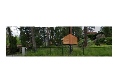 Fotografi av en tomt med et hus i bakgrunnen, sett fra gaten.