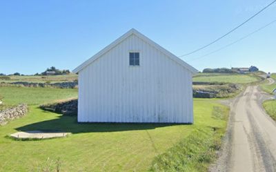 Fotografi av en hvit bygning i et landlig landskap.
