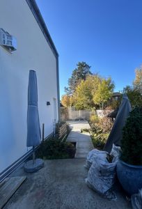 Fotografi av en uteplass med en terrasse, en trapp og en hage.