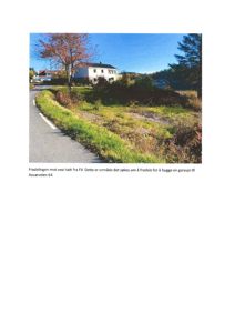 Fotografi av et fradelingsområde mot vest fra FV, med en eksisterende hvit bygning i bakgrunnen.