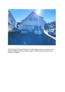 Fotografi av et uteparkeringsområde med biloppstillingsplasser foran en garasje og en bolig. Bildet viser eksisterende forhold, inkludert terrengforhold og plassering av kjøretøy.