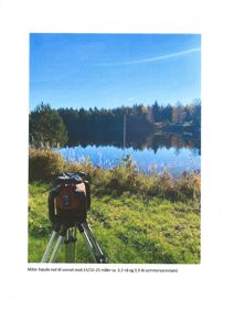 Fotografi av et måleutstyr (totalstasjon) på et stativ ved en vannflate, med en tekstbeskrivelse om måling av vannstand.