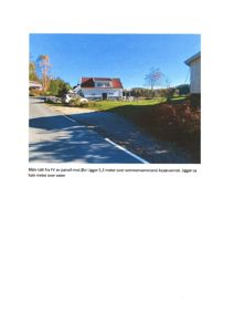 Fotografi av en eiendom sett fra veien (fra FV mot Øst). Bildet viser huset, kjørevei, og omgivelsene.