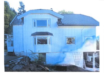 Fotografi av en blåfarget, toetasjes villa sett fra fronten.