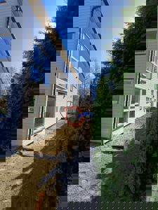 Fotografi av en hvitfarget fasade på et hus under bygging eller renovering, med en markert del av veggen.