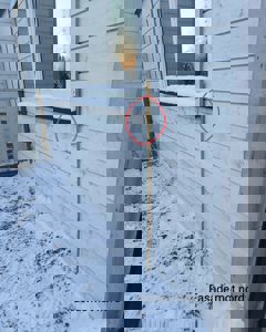 Fotografi av en hvit panelfasade med vindu, snø på vinduskarmen og et målebånd som viser høyde. Bildet har en tekstmerking 'Fasade mot nord' og en rød sirkel som markerer en spesifikk detalj.