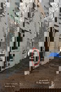 Fotografi av fasaden mot vest på en nybygd eller renovert bolig, med tekstbeskrivelse og markeringer.