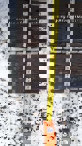 Fotografi av en fasade med et målebånd som viser høyde, med teksten 'Inngang fasade mot øst'.