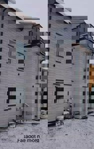 Fotografi av en hvitfarget bygning med snø på taket og bakken, med teksten 'Fasade mot nord' nederst.