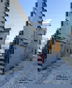 Fotografi av en bygning med snø på bakken og tak, med teksten 'Fasade mot øst' i bunnen.