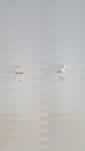 Fotografi av en hvit røykvarsler montert på et hvitt tak.