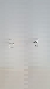 Fotografi av en hvit røykvarsler montert på et hvitt tak.