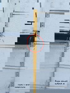 Fotografi av en fasade med et målebånd og en markering som viser detaljer om vindusbrysting eller taklist.