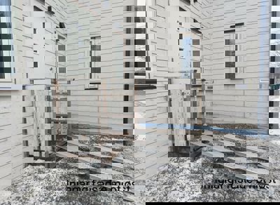 Fotografi av en inngang til en bygning med en midlertidig rampe, sett fra fasaden mot øst.