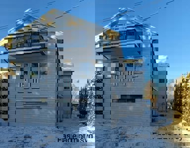 Fotografi av en hvitfarget villa med balkong og snødekke, med teksten 'Fasade mot syd' i bunnen.