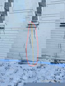 Fotografi av en fasade med hvite paneler, et vindu og en gul målebånd som er plassert langs veggen for å vise høyde. Bildet har også teksten 'fasade mot øst' i bunnen.