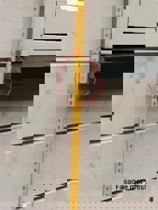 Fotografi av en fasade med et målebånd og en markering som viser en spesifikk detalj ved vindusrammen.