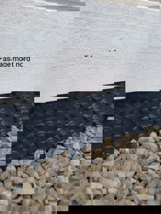 Fotografi av en fasade med tekst 'Fasade mot nord' og en svart, punktert materiale under fasaden.