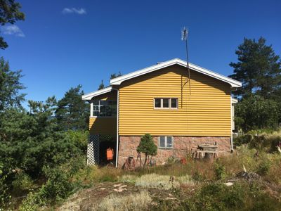 Fotografi av en gul fasett med steinfundament, sett fra siden.