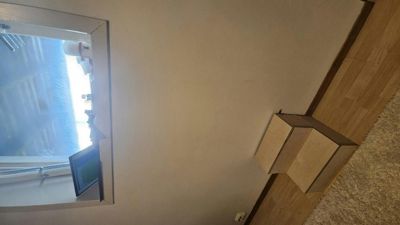 Fotografi av en vegg med et vindu og en del av gulvet i et rom.