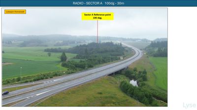 Fotografi av en landsbygd med en vei og en markert referansepunkt for en radiosektor.